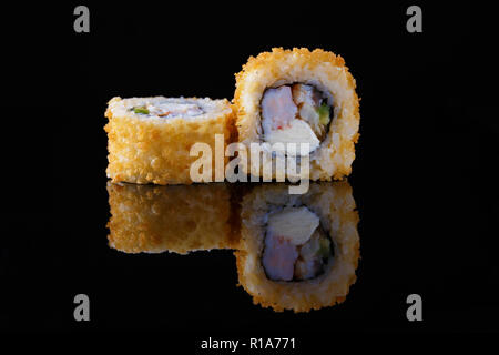 Appetitoso al forno rotolo di sushi con pesce su uno sfondo nero con la riflessione Menu e ristorante di concetto di spazio di copia Foto Stock