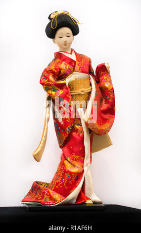 Giapponese Geisha bambola in rosso kimono isolati su sfondo bianco Foto Stock