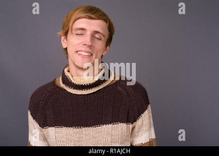 Ritratto di giovane uomo bello sorridente con gli occhi chiusi Foto Stock