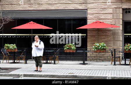 Donna in piedi, street, marciapiede, rosso ombrelloni, edificio, Downtown Boston Massachusetts, STATI UNITI D'AMERICA Foto Stock