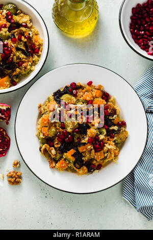 Delizioso autunno festose insalata di zucca, i cavoli di Bruxelles, la quinoa, noci, le cipolle caramellate e i semi di melograno. Un sano Vegan ricetta Gourmet Foto Stock