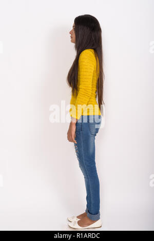 Corpo pieno shot vista di profilo di giovane donna indiana di nuovo in piedi Foto Stock