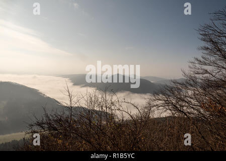 Autunno paesaggio di montagna con nebbia sul fiume Vah valley, gamme della montagna e cielo blu da Klapy hill in Javorniky montagne vicino Povazska Bystrica ci