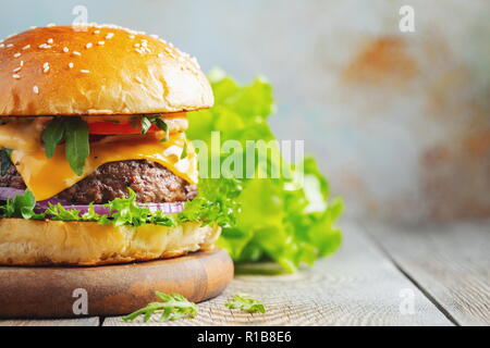 Due freschi fatti in casa hamburger con patatine fritte su un tavolo di legno. Con spazio di copia Foto Stock