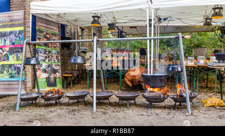 Cucina Outdoor n vasi di ferro sul fuoco aperto in una foresta a un evento della fauna selvatica in Ede nei Paesi Bassi Foto Stock