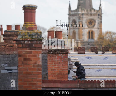 Lavoratori fissare un tetto nella vecchia città di Stratford upon Avon con la Chiesa della Santa Trinità nel retro dello sfondo. 8.11.2018. Foto Stock