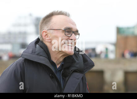 Folkestone, Kent, Regno Unito. Xi Nov, 2018. Poeta guerra Wilfred il proprio volto infine emerso dalla spiaggia di sabbie assolate come il sole è uscito. Danny Boyle è arrivato a unire le centinaia di persone si sono radunate per commemorare il centenario di armistizio. Credito: Monica pozzetti/Alamy Live News Foto Stock