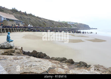 Folkestone, Kent, Regno Unito. Xi Nov, 2018. Poeta guerra Wilfred il proprio volto infine emerso dalla spiaggia di sabbie assolate come il sole è uscito. Danny Boyle è arrivato a unire le centinaia di persone si sono radunate per commemorare il centenario di armistizio. Credito: Monica pozzetti/Alamy Live News Foto Stock