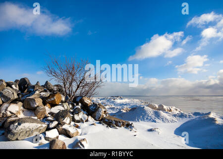 Incantevole paesaggio invernale con una vista sul mare. pietre sulla spiaggia nella stagione invernale Foto Stock