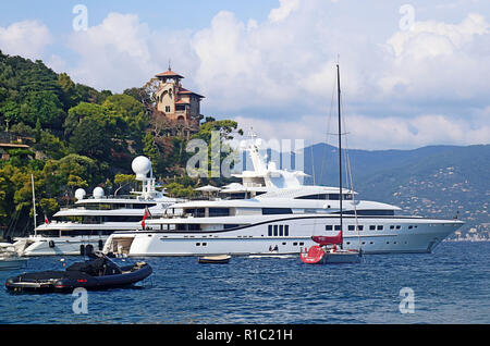 PORTOFINO, Italia - Luxury Yacht ormeggiati in porto di Portofino e una villa di lusso che si affaccia sulla baia Foto Stock