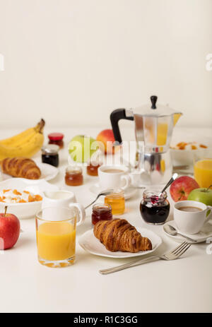 Il momento della colazione. Croissant e succo d'arancia, marmellata e miele. Caffè con panna o latte. Frutta - banane, il rosso e il verde di mele. Ricotta con panna acida Foto Stock