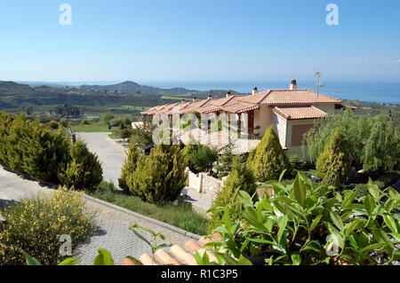 Paliouri, Grecia - 05 Maggio 2012: viste panoramiche della Scenic terreno montuoso, il blu del mare e le ville del Akritas Ef Zin complesso di ville. Foto Stock