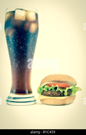 Grande bicchiere di cola con lussureggianti gustoso hamburger isolato su uno sfondo bianco Foto Stock