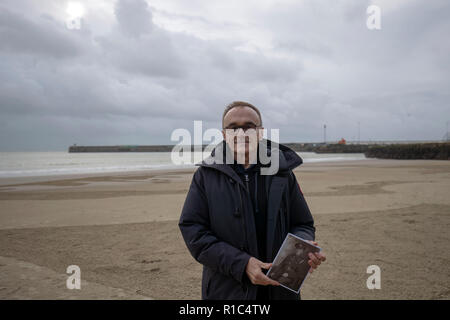 Danny Boyle sorge accanto ad una spiaggia disegno del poeta guerra Wilfred Owen durante le pagine del mare evento commemorativo a Folkestone nel centesimo anniversario della firma dell'armistizio che ha segnato la fine della Prima Guerra Mondiale. Foto Stock