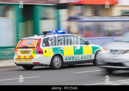 Ambulanza risposta veloce auto con luci blu lampeggiante sul modo per chiamata di emergenza nel West Sussex, Regno Unito. Motion Blur effetto. Foto Stock