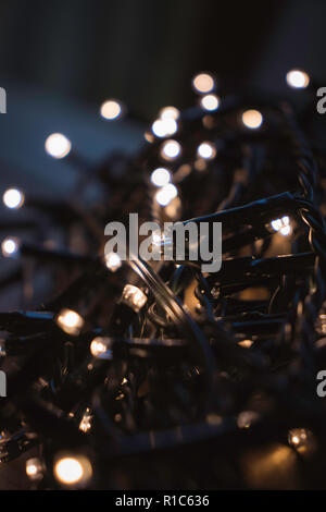 Favola di natale luci avvolto intorno alla scheda su una tavola di legno di notte Foto Stock