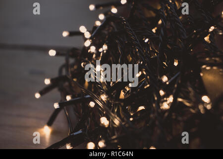 Favola di natale luci avvolto intorno alla scheda di notte in un'impostazione Scuro Foto Stock