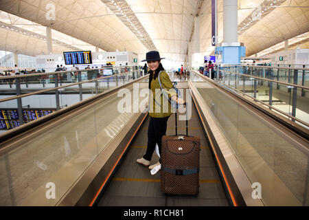 I viaggiatori thai Donna che cammina e trascinare i bagagli sulle scale nel terminal a Chek Lap Kok di Hong Kong o Aeroporto Internazionale il 10 settembre 2018 a HON Foto Stock