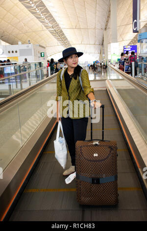 I viaggiatori thai Donna che cammina e trascinare i bagagli sulle scale nel terminal a Chek Lap Kok di Hong Kong o Aeroporto Internazionale il 10 settembre 2018 a HON Foto Stock