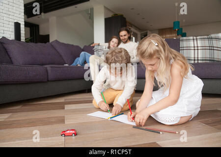 Felice di giovani famiglie con bambini trascorrere il tempo libero a casa Foto Stock