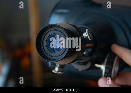 Close up oculare del telescopio con mano d'uomo. Telescopio tuning Foto Stock