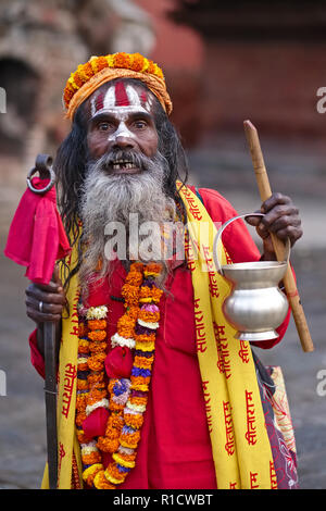 Un piuttosto wild-eyed sadhu o cosiddetti indù uomo santo a Durbar Square, Kathmandu, Nepal, tipicamente vestite per il beneficio delle telecamere turistica Foto Stock