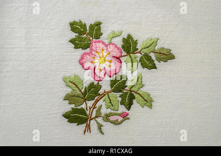 Yerevan, Armenia, 04,Giugno,2018: Flower Pink rosa tea con un bocciolo e foglie, ricamato un satin stitch sulla ruvida stoffa di cotone Foto Stock