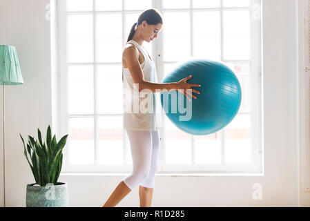 Ahtletic bella donna training at home - Giovane ragazza fitness facendo nel suo appartamento, concetti sul fitness, sport e salute Foto Stock