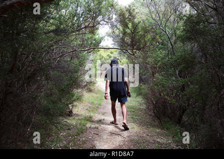 Curioso l uomo si piega verso il basso per ottenere attraverso una lacuna nelle boccole, mentre le escursioni. Foto Stock