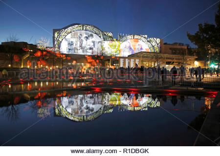 Edinburgh, Regno Unito. 11 Novembre, 2018. L'edificio del parlamento scozzese illuminata sul il giorno dell'Armistizio con immagini che raccontano la storia della guerra mondiale 1 conflitto a fianco di un rotolo di onore di coloro che sono morti, riflesso nel laghetto ornamentale. Credito: Craig Brown/Alamy Live News. Foto Stock
