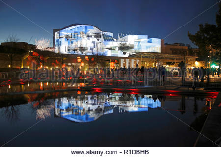 Edinburgh, Regno Unito. 11 Novembre, 2018. L'edificio del parlamento scozzese illuminata sul il giorno dell'Armistizio con immagini che raccontano la storia della guerra mondiale 1 conflitto a fianco di un rotolo di onore di coloro che sono morti, riflesso nel laghetto ornamentale. Credito: Craig Brown/Alamy Live News. Foto Stock