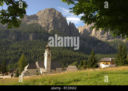 Vista verso il gruppo del Sella nelle Dolomiti italiane, davanti una tipica chiesa alpina Foto Stock