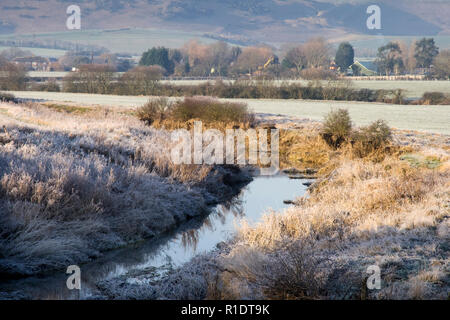 Una vista attraverso il Fiume Cuckmere verso Alfriston in East Sussex su un gelido inverno del giorno Foto Stock