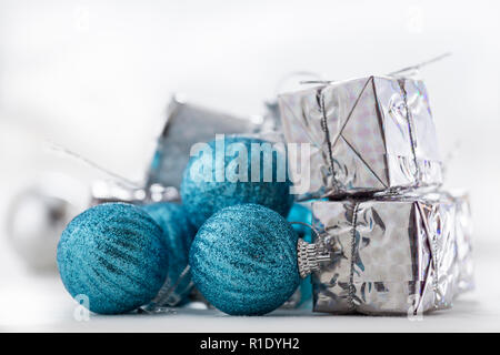 Set di ornamenti per l'albero di Natale, diverse sfere blu, altri argento e confezioni regalo avvolto in carta argentata Foto Stock