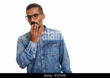 Giovani indiani man looking colpevole ritratto in studio contro uno sfondo bianco Foto Stock
