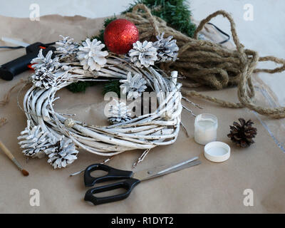 Preparazioni di natale. Il processo di fabbricazione di una ghirlanda di Natale con le proprie mani. Corona di avvento, o corona di Avvento, è una tradizione cristiana Foto Stock