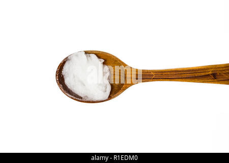 Vergine piena di olio di noce di cocco oppure olio di copra, è un olio commestibile. Su marrone cucchiaio di legno isolato su bianco. Sostituto per shop creme concetto. Foto Stock