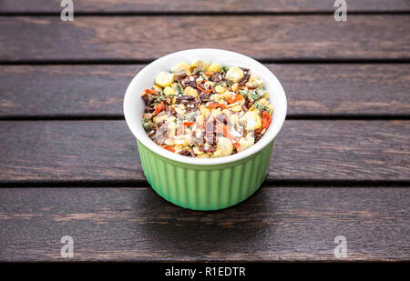 Ciotola di zuppa di essiccato mix, ingredienti diversi su legno marrone con sfondo spazio copia. Foto Stock