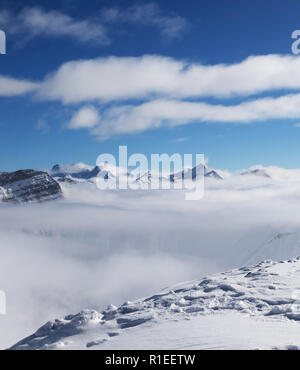 Pendio nevoso e dalla luce diretta dei raggi solari montagna sotto nuvole a freddo giorno di sun. Montagne del Caucaso in inverno, Georgia, regione Gudauri. Punto di vista sulla vetta del monte Kudebi. Foto Stock