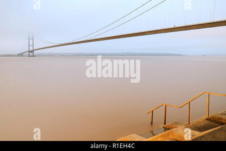 Scafo, Yorkshire, Regno Unito. Ponte Humber sopra l'estuario come dawn si rompe in corrispondenza di alta marea in autunno, nello Yorkshire, Regno Unito. Il mattino in autunno, nello Yorkshire, Regno Unito. Foto Stock