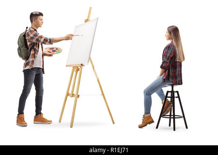 Lunghezza piena ripresa di profilo di un ragazzo adolescente pittura modello femminile su una tela isolati su sfondo bianco Foto Stock