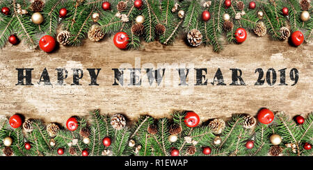 Felice anno nuovo 2019 scritto su un rustico listone decorate con ornamento di Natale su rami di pino Foto Stock