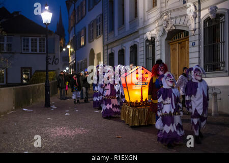 Il Carnevale di Basilea 2018. Rheinsprung Basel, Svizzera - Febbraio 19th, 2018. Un piccolo gruppo di carnevale con la loro lanterna accesa nella città vecchia Foto Stock