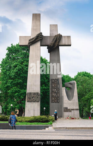 Monumento di Poznan, vista delle persone che visitano il Monumento alle vittime del giugno 1956 in Piazza Adam Mickiewicz (Plac Mickiewicza), Poznan, Polonia. Foto Stock