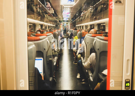 Molte persone di sedersi su un tubo sul treno in movimento per destinazioni per lavoro o per piacere come vacanza. Connessione internet wifi moderno collegato durante il t.r.a. Foto Stock