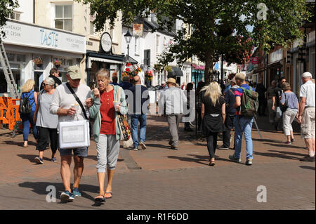 La gente a piedi attraverso Sidmouth centro città Foto Stock