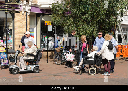 La gente a piedi attraverso Sidmouth centro città Foto Stock