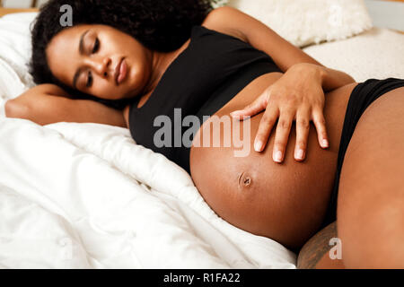 Close up della donna incinta toccando il suo ventre Foto Stock