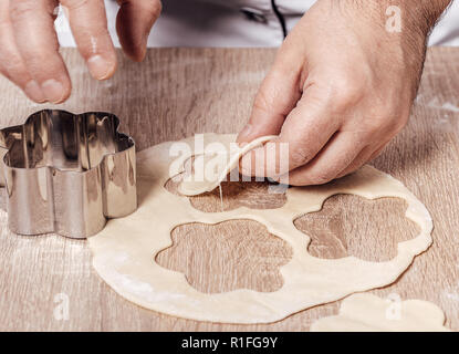 Uomo con stampo da forno per biscotti, mani closeup Foto Stock