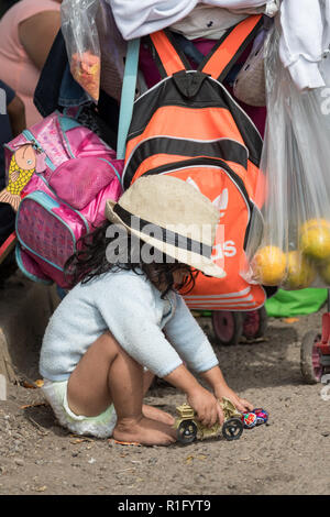 Irapuato, Guanajuato, Messico. 12 Nov 2018. Un giovane rifugiato honduregne con l'America centrale caravan migranti gioca con un giocattolo donato sotto un cavalcavia autostradale come la sua famiglia attende prima di proseguire il viaggio verso nord-ovest verso la frontiera degli Stati Uniti Novembre 12, 2018 a Irapuato, Guanajuato, Messico. Il caravan è stato sulla strada per un mese è a metà strada lungo il loro viaggio a Tijuana. Credito: Planetpix/Alamy Live News Foto Stock